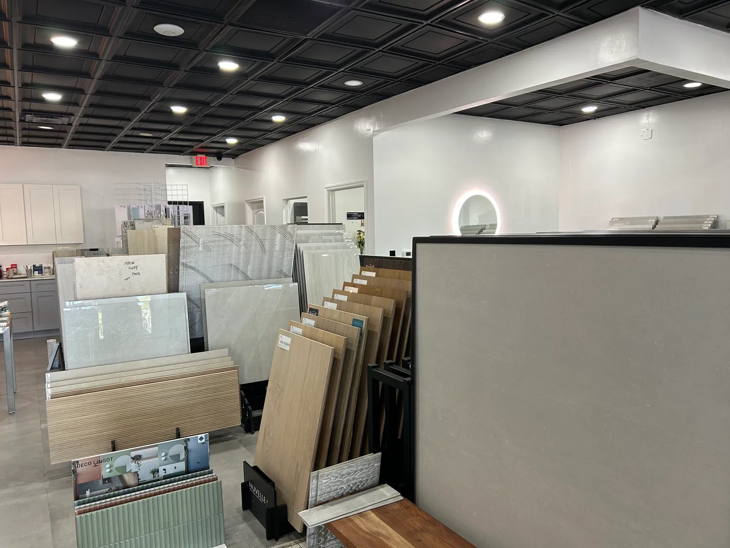 Row of marble and quartz slab samples lined against the showroom wall