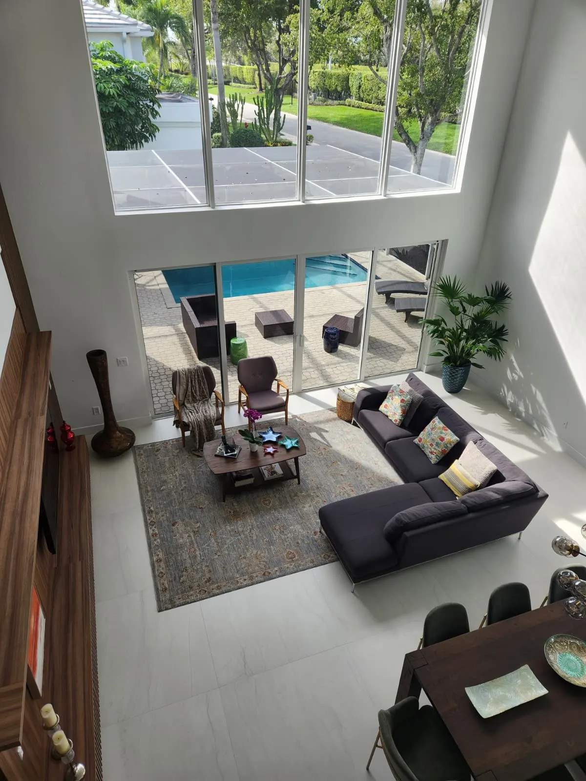 Open-concept living room with large-format tile floor and pool view